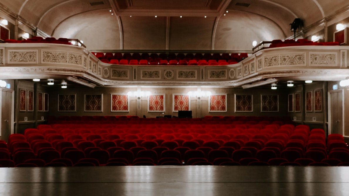 A theatre auditorium filled with red fixed seating