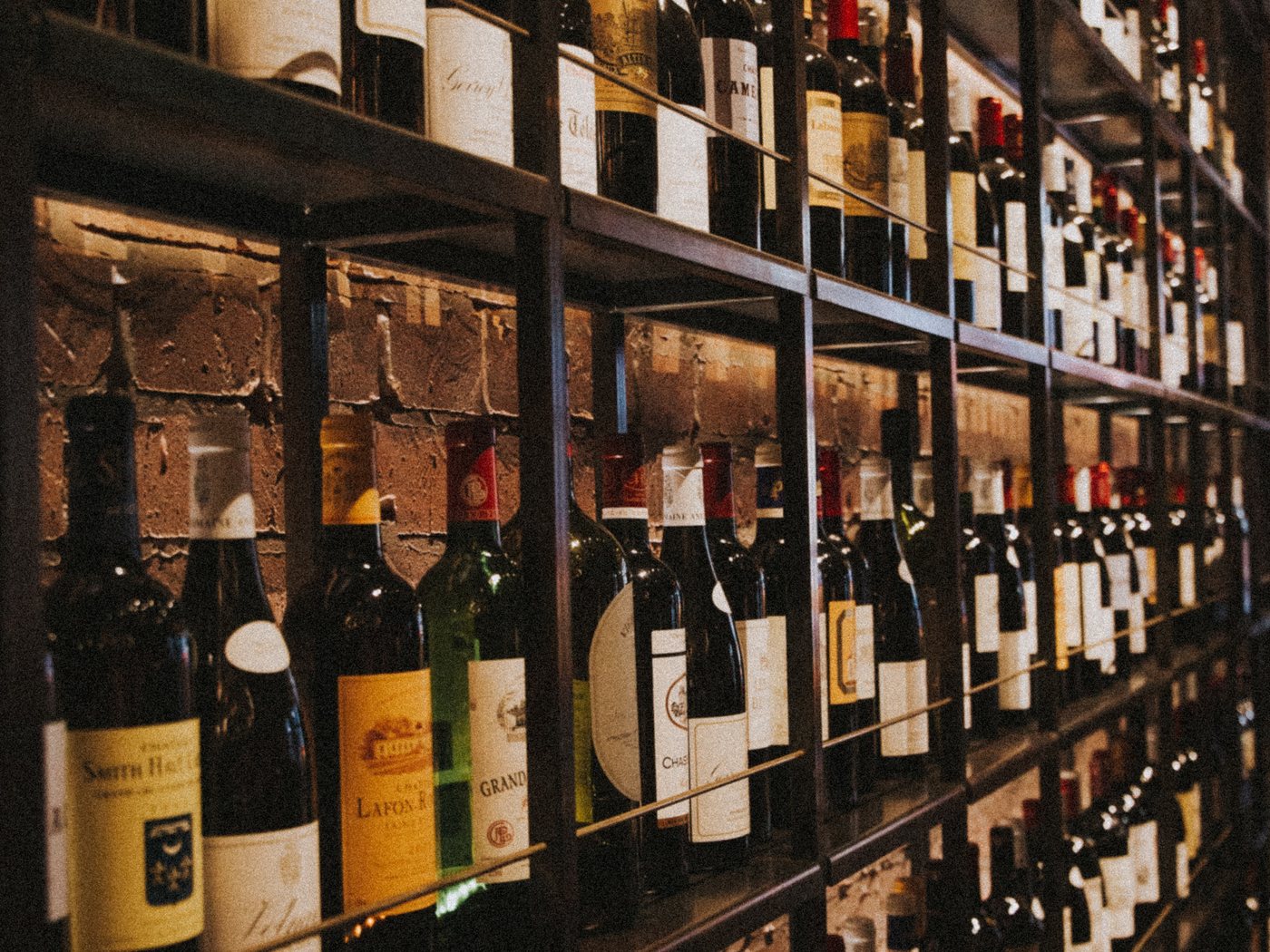 Rows of wine bottles on shelves in a merchant's store